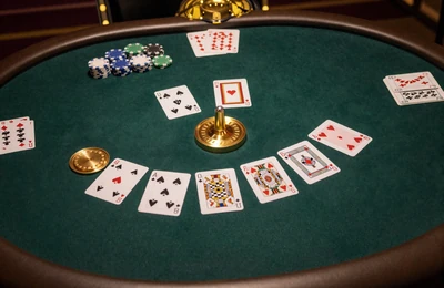 Eleganter Baccarat-Tisch mit Karten und goldenen Chips auf dunkelgr&uuml;nem Filz von oben
